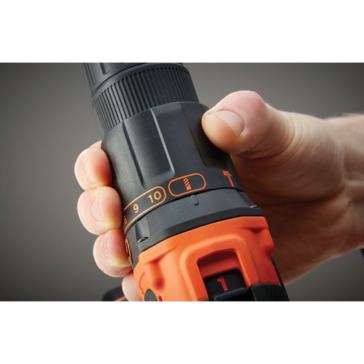 Close-up photo of hand adjusting torque setting on BLACKDECKER BDCHD18 cordless drill, showing control dial.