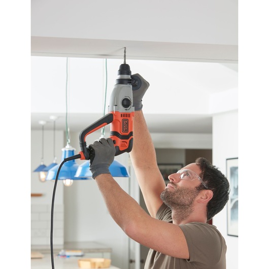 Photo of BLACKDECKER BEHS02K corded hammer drill held by person drilling into ceiling indoors.