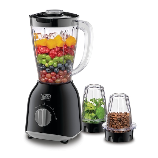 A BLACK+DECKER blender with a large pitcher filled with ice cubes and various colorful fruits. Next to the blender are two smaller containers: one filled with fresh green herbs, and the other with coffee beans.