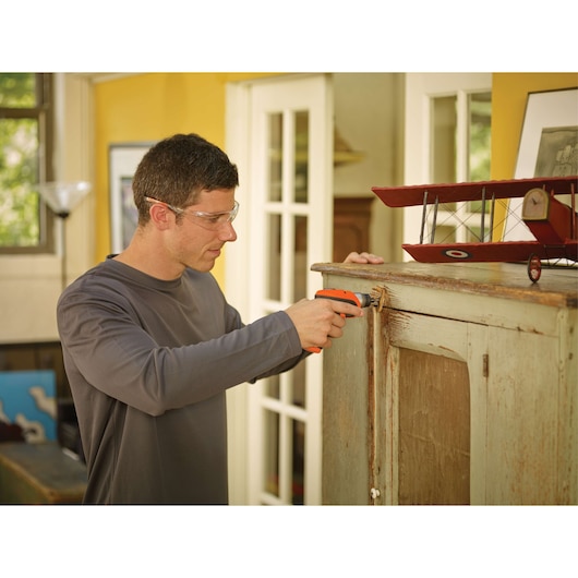 BLACKDECKER CS3652LC cordless screwdriver used on a cabinet indoors, model holding tool horizontally.