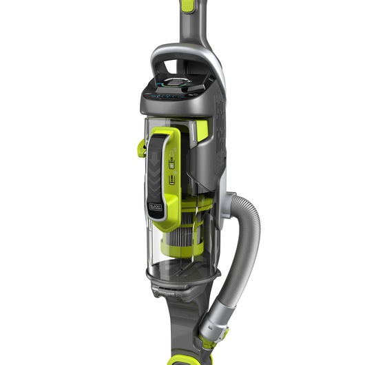 A close-up image of a BLACK+DECKER upright vacuum cleaner featuring a transparent dust container, grey and green accents, and a flexible hose attached to the side.