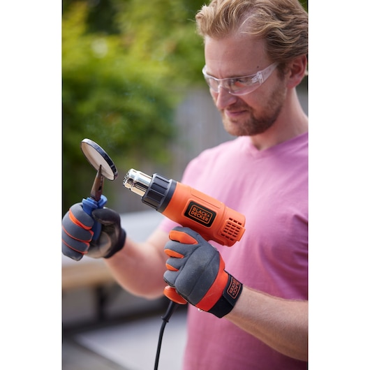 A BLACK+DECKER Heat Gun removing paint from an old jar top