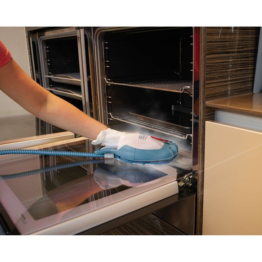 BLACKDECKER FSH10SMP steam cleaning glove used to clean oven door in kitchen setting.