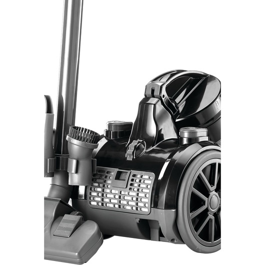 Close-up image of a BLACK+DECKER canister vacuum cleaner, showing the wheels, brush attachment, and main body in black and grey colors.